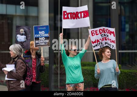 Protesta per il primo anniversario della "Camera da Letto", fuori da un Hyde Park, una delle più costose residenze di Londra. Il Welfare Reform Act del 2012, entrato in vigore il 1° aprile 2013, prevedeva modifiche alle norme in materia di benefici per gli alloggi. Questi cambiamenti includono una 'penalità di sotto occupazione' che riduce l'importo di beneficio pagato ai richiedenti se sono considerati avere troppo spazio vitale nella proprietà su cui stanno rivendicando il beneficio dell'alloggio, questi sono diventato conosciuto come 'tassa della Camera da Letto'. One Hyde Park, Knightsbridge, Londra, Regno Unito. 5 Apr 2014 Foto Stock