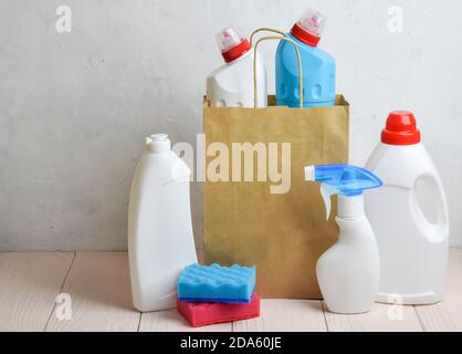 Detersivi su un tavolo di legno. Contenitore in plastica. Prodotti chimici per uso domestico. Pulizia della casa, appartamento. Foto Stock