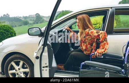 Donna in sedia a rotelle che lascia l'auto Foto Stock