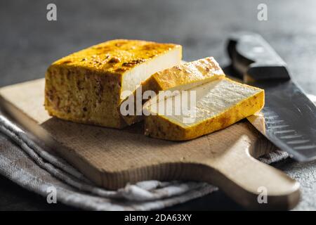 Morse di tofu marinato su tagliere. Foto Stock