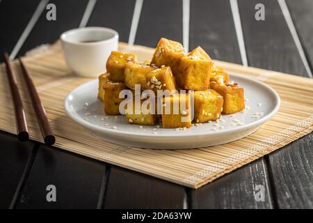 Morsi di tofu fritto su piatto. Foto Stock