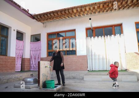 (201110) -- DONGXIANG, 10 novembre 2020 (Xinhua) -- UN abitante del villaggio raccoglie l'acqua al villaggio di Bulenggou nella contea autonoma di Dongxiang della prefettura autonoma di Linxia Hui, nella provincia di Gansu della Cina nord-occidentale, il 9 novembre 2020. Bulenggou Village era un'area gravemente impoverita. Fin dall'inizio del lavoro di alleviamento della povertà, il villaggio è cambiato insieme a migliori infrastrutture, che consentono agli abitanti del villaggio di accedere all'acqua potabile, alle strade, al centro sanitario e alla scuola primaria ben attrezzata. Allevamento di bestiame è diventato l'industria leader del Villaggio di Bulenggou, dove gli abitanti del villaggio hanno assistito al loro reddito inc Foto Stock