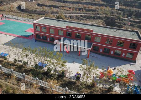 (201110) -- DONGXIANG, 10 novembre 2020 (Xinhua) -- Foto aerea scattata il 9 novembre 2020 mostra la vista della scuola elementare di Bulenggou Villaggio di Bulenggou nella Contea Autonoma di Dongxiang della Prefettura Autonoma di Linxia Hui, nella provincia di Gansu, nella Cina nord-occidentale. Bulenggou Village era un'area gravemente impoverita. Fin dall'inizio del lavoro di alleviamento della povertà, il villaggio è cambiato insieme a migliori infrastrutture, che consentono agli abitanti del villaggio di accedere all'acqua potabile, alle strade, al centro sanitario e alla scuola primaria ben attrezzata. L'allevamento è diventato l'industria leader del Bulenggou Village, dove v Foto Stock