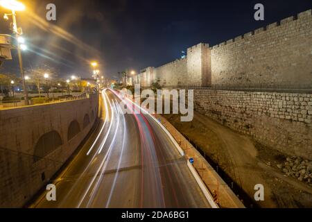 Lunga esposizione sulla strada principale intorno alle mura della vecchia Gerusalemme di notte, sullo sfondo delle mura Foto Stock