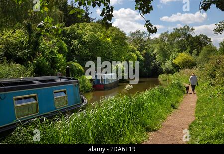 Towpath e il canale di Oxford e le barche strette a Lower Heyford, Oxfordshire, Inghilterra Foto Stock