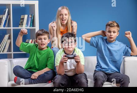 Amici adolescenti divertirsi, giocare giochi per computer, dopo che tutti i compiti della scuola è fatto. Foto Stock