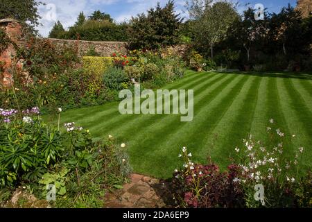 English Garden con prato a strisce e boarders estivi, Inghilterra, Europa Foto Stock