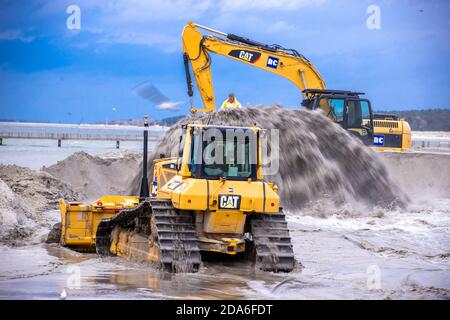 05 novembre 2020, Meclemburgo-Pomerania occidentale, Lubmin: Bulldozer e escavatori spargono la sabbia bagnata sulla spiaggia del Mar Baltico. Dopo la prima ondata di tempeste di questo autunno del 16.10.2020, il lavoro di protezione costiera iniziato lo scorso anno è stato ritardato. Tempesta Gisela causò inondazioni e circa 1,000 metri cubi di sabbia furono lavati via. La nuova sabbia viene ora ridistribuita sulla spiaggia in almeno cinque metri cubi di figura. Foto: Jens Büttner/dpa-Zentralbild/ZB Foto Stock