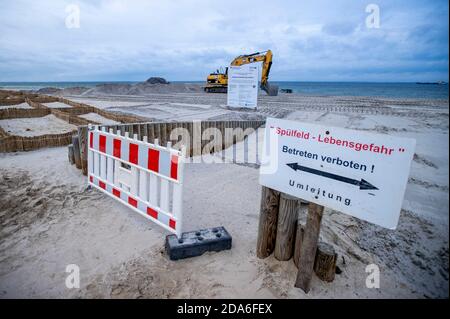 05 novembre 2020, Meclemburgo-Pomerania occidentale, Lubmin: Bulldozer e escavatori spargono la sabbia bagnata sulla spiaggia del Mar Baltico. Dopo la prima ondata di tempeste di questo autunno del 16.10.2020, il lavoro di protezione costiera iniziato lo scorso anno è stato ritardato. Tempesta Gisela causò inondazioni e circa 1,000 metri cubi di sabbia furono lavati via. La nuova sabbia viene ora ridistribuita sulla spiaggia in almeno cinque metri cubi di figura. Foto: Jens Büttner/dpa-Zentralbild/ZB Foto Stock