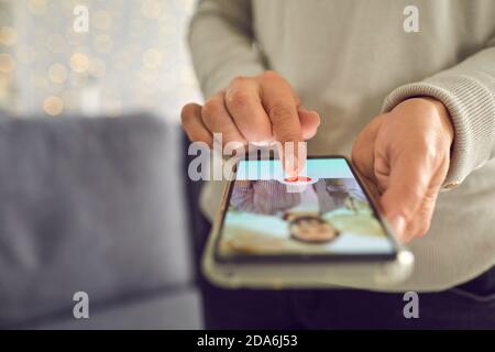 Donna premendo il pulsante mi piace sotto la bella foto del profilo dell'uomo su app di datazione Foto Stock