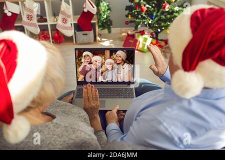 I nonni felici in Santa cappelli video che chiamano la loro famiglia sopra Vacanze di Natale in blocco Foto Stock