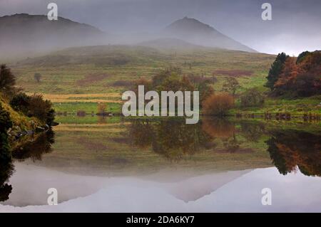 Dunsapie Loch, Edimburgo, Scozia, Regno Unito. 10 novembre 2020. La nebbia continua a persistere sulla capitale scozzese, ma si raduna verso mezzogiorno. Nella foto: Dunsapie Loch nel Parco Holyrood, che riflette la cima della sede di Arthur nelle sue acque ferme. Credit: Arch White/Alamy Live News. Foto Stock