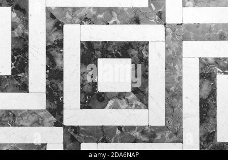 Pavimento in marmo di pietra d'epoca con motivi geometrici in bianco e nero, vista dall'alto, texture foto di sfondo Foto Stock