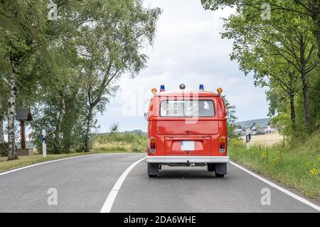 VW T1 Fire Engine rosso fuoco auto Oldtimer auto classica guida su strada. Foto Stock