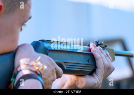 La ragazza tiene un fucile e prende mira Foto Stock