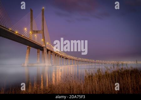 Ponte Vasco de Gama al tramonto con le luci accese Foto Stock