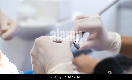 Giovane donna dentista. Ricevimento all'ortodontista. Sostituzione dei rinforzi. Lucidatura. Gel bonding. Foto Stock