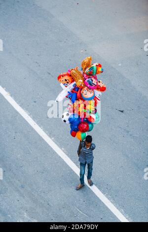 Giovane uomo nepalese che vende palloncini a Patan, Nepal Foto Stock