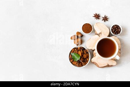 Bevanda a base di chaga ai funghi con caffè su sfondo bianco. Chicchi di caffè, pezzi di chaga tritati, anice e una tazza con una bevanda sana. Spazio di copia Foto Stock