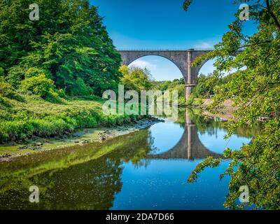 Una giornata estiva brillante a Washington, Regno Unito con il Viadotto Victoria che getta il suo riflesso attraverso l'abbigliamento River Foto Stock