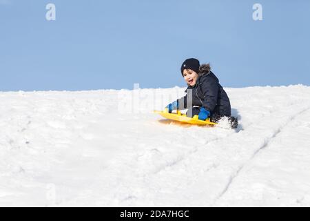 Ragazzo sulla slitta. Slittino in inverno Foto Stock