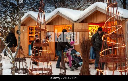 Ettal, Germania/Baviera – 31 dicembre 2019: Mercatino di Natale innevato con negozi illuminati in capanne di legno con regali e decorazioni fatte a mano. Foto Stock