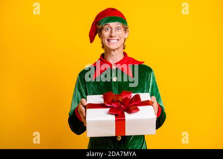 Ritratto del suo elfo simpatico allegro divertente ragazzo tenere in mani dando giftbox congrats congratulazioni si è isolato troppo luminoso Foto Stock