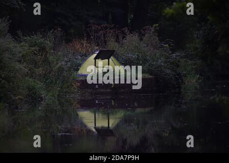 Una tenda si riflette nelle acque ferme del Bellissimo canale di Basingstoke vicino ad Aldershot nell'Hampshire Foto Stock
