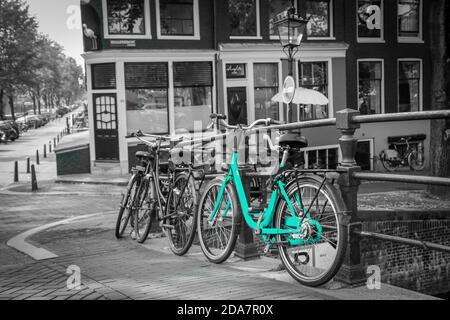 Una bici azzurra per le strade di Amsterdam. Simbolo per il trasporto urbano pulito ed ecologico. Isolato su sfondo bianco e nero. Foto Stock