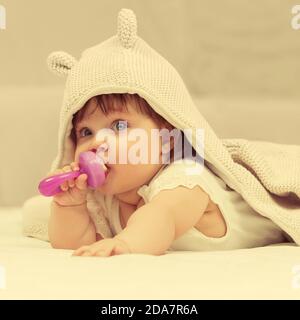 Bambina in felpa con cappuccio che gioca con il giocattolo coperta a casa Foto Stock