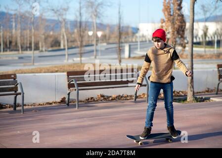 Skateboarder maschile a cavallo e pratica skateboard in città all'aperto Foto Stock