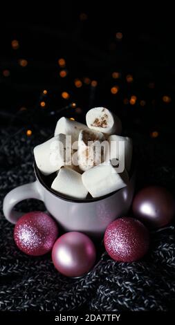 Cioccolato caldo di Natale con marshmallows su un tavolo con luci bokeh. Messa a fuoco selettiva - foto verticale Foto Stock