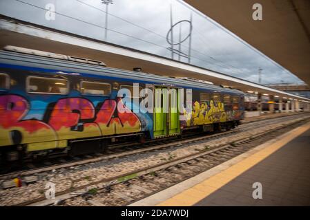 teni, italia maggio 28 2020 : treni che si impanano alla stazione a velocità con persone all'interno e colorate da graffiti Foto Stock