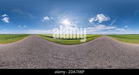 Visualizzazione panoramica a 360 gradi di panoramica hdri completamente sferica senza cuciture con angolo di 360 gradi vecchia strada asfaltata senza traffico tra i campi con blu chiaro cielo in progetto equirettangolare