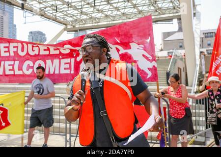 Un manifestante parla ai colleghi durante la manifestazione.UN raduno di "Stop the hate" è stato tenuto dai manifestanti DI ANTIFA (Anti-fascista) a Nathan Phillip Square in opposizione al WCAI (Worldwide Coalition Against Islam) Canada, un gruppo che ha previsto una protesta lo stesso giorno. Foto Stock