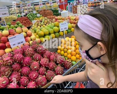 25 settembre 2020. Piracicaba, SP, Brasile. Bambino con maschera che sceglie frutta in un supermercato. Foto Stock