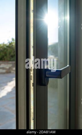 Dettaglio della porta in alluminio. Vista in primo piano del telaio della finestra in metallo. Efficienza energetica, profilo di sicurezza, sfocatura dello sfondo esterno Foto Stock