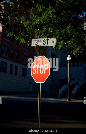 Un segnale di stop luminoso, rosso e riflettente si distingue contro il nero in corrispondenza di un incrocio. Ad Arlington, Virginia. Foto Stock