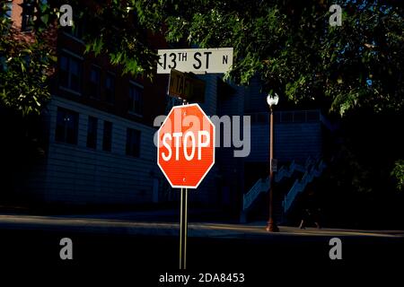 Un segnale di stop luminoso, rosso e riflettente si distingue contro il nero in corrispondenza di un incrocio. Ad Arlington, Virginia. Foto Stock