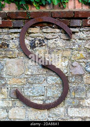 Piastra di ancoraggio o supporto parete su vecchio muro esterno di pietra focaia e muro di mattoni nel villaggio di Itchenor, Sussex occidentale, Inghilterra, Regno Unito Foto Stock