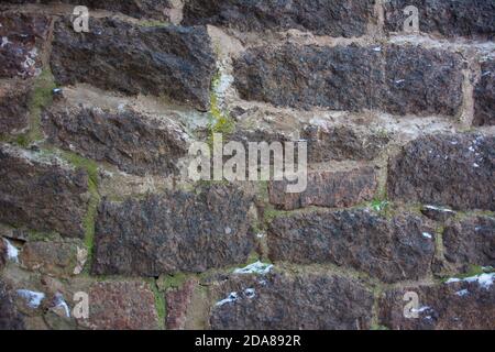 Muro del castello fatto di pietre antiche. Parete del castello fatta di vecchie trame di pietre per il disegno e sfondo della foto. Foto Stock