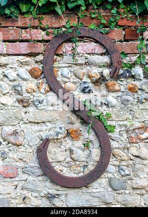 Piastra di ancoraggio o supporto parete su vecchio muro esterno di pietra focaia e muro di mattoni nel villaggio di Itchenor, Sussex occidentale, Inghilterra, Regno Unito Foto Stock