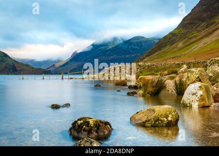 Crummock Water nel nord-ovest Lake District National Park, Cumbria. Le campane intorno a Buttermere in lontananza Foto Stock