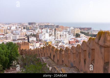 Vista aerea della città dal Mar Mediterraneo e il suo porto incorniciato da un'antica cinta muraria. Appartamenti e business buildings in città. Alcazaba, Almer Foto Stock