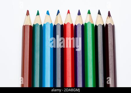 Vista dall'alto di matite colorate in colori diversi, pattern di righe utilizzato, che mostra le punte della penna su sfondo bianco uniforme Foto Stock
