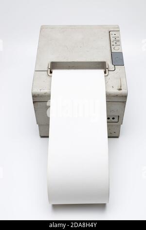 Carta termica bianca che si sta disconnettendo da una vecchia stampante per ricevute retrospettiva, questa stampante per ricevute vecchia e usata era collegata a un registratore di cassa, io sono usato e di Foto Stock