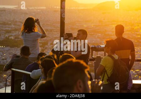 I turisti scattano foto sui loro smartphone al punto di osservazione sulla collina di Lycabettus nel centro di Atene Grecia - Foto: Geopix Foto Stock