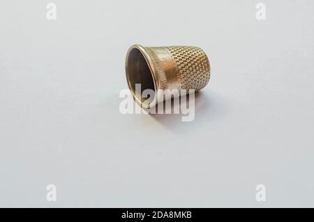 Un tamburo metallico con più creste per spingere l'ago da cucire poggia su uno sfondo bianco. Foto Stock