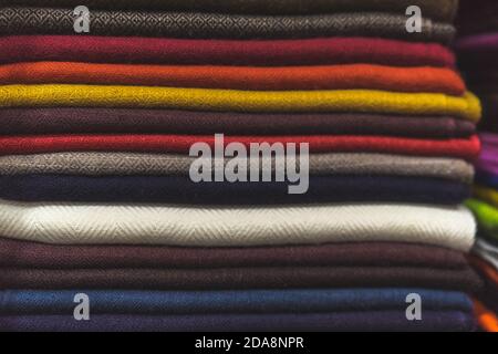 primo piano di tessuto colorato, un mucchio di tessuto di cashmere, una pila di vestiti colorati, un mucchio di vestiti Foto Stock