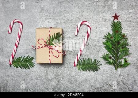 2021 buon Natale e Felice anno nuovo, sfondo fatto con dono, canne caramelle e rami di albero sempreverdi, layout creativo. Concetto di vacanza invernale. Foto Stock